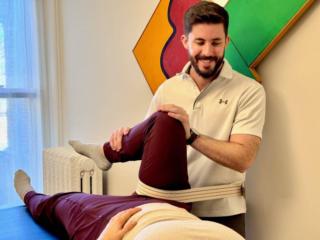In-home physical therapist performing manual therapy technique with runner