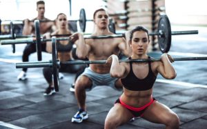 Group of sporty people are working out in gym. gym training. men and women are doing exercises with barbells. Weightlifting.