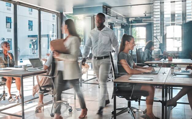 man and woman walking around busy office